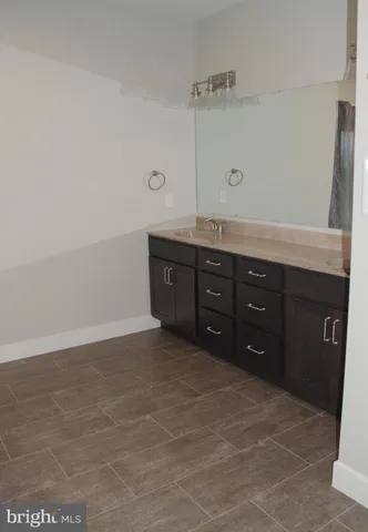 a spacious bathroom with a granite countertop sink and a bathtub