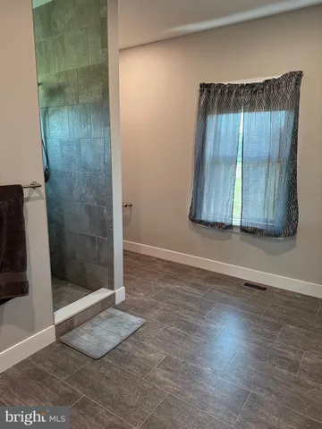 an empty room with wooden floor and a bathroom