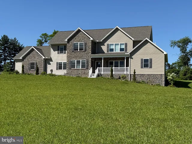 a front view of a house with a yard and trees