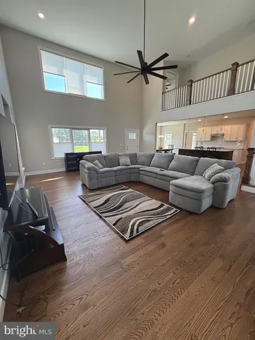 a living room with furniture ceiling fan and a wooden floor