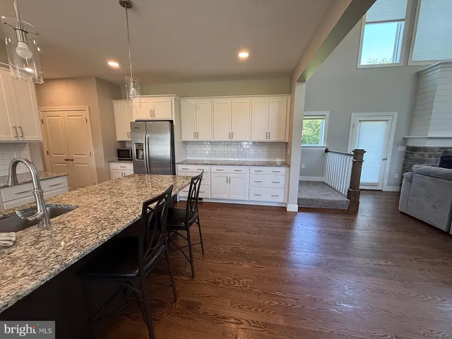 a kitchen with granite countertop kitchen island wooden cabinets and stainless steel appliances