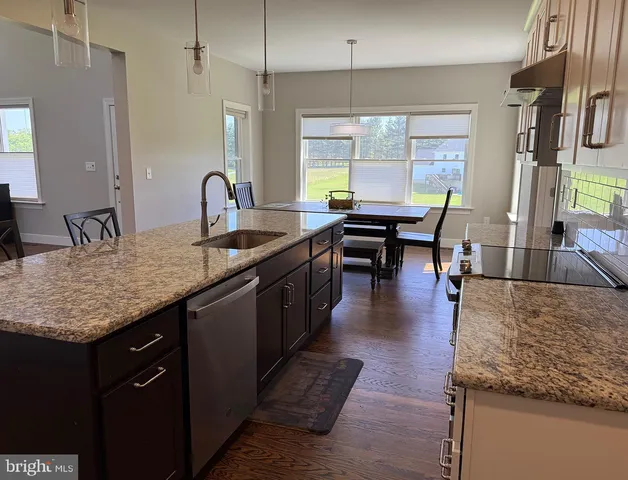 a kitchen with granite countertop a sink a counter top space and living room view