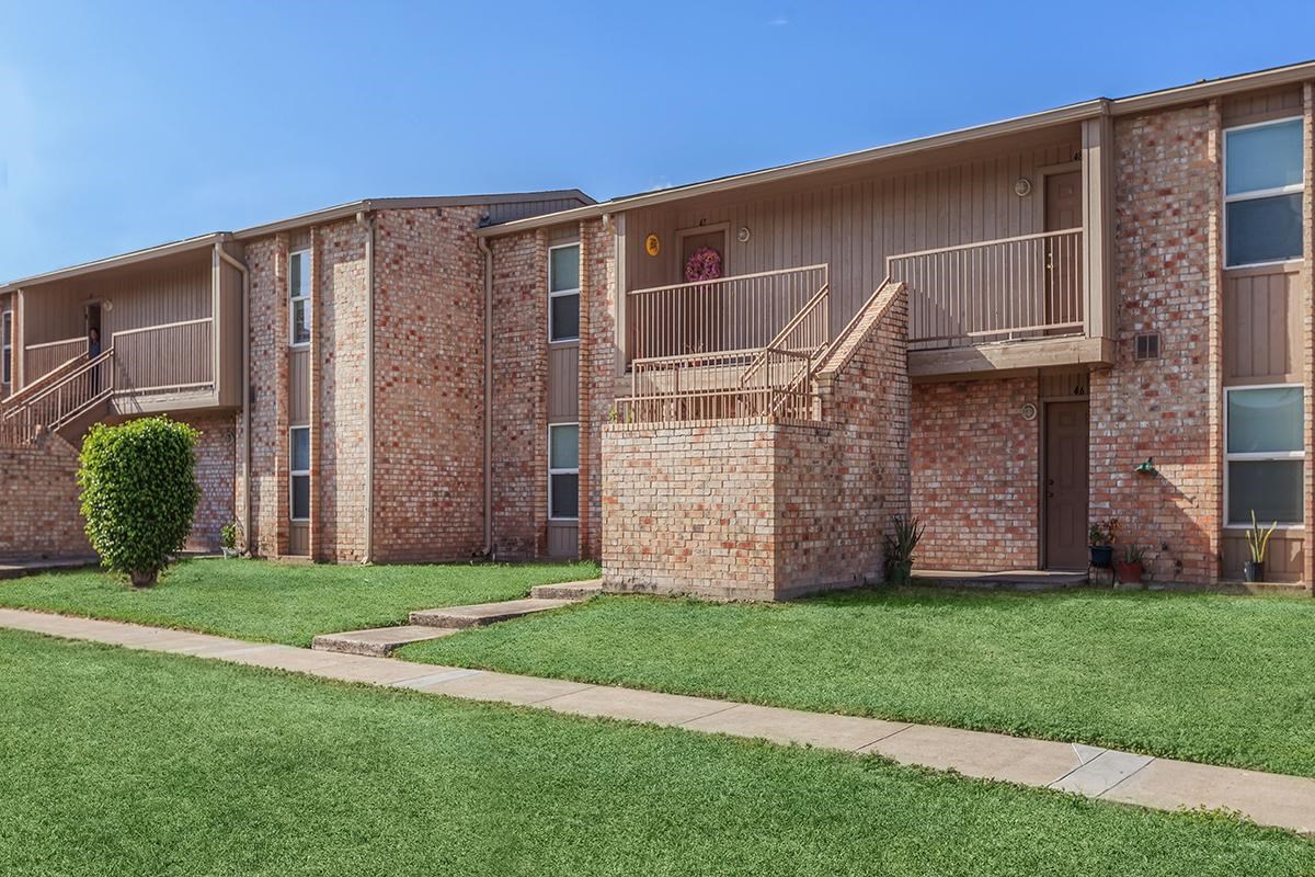 2401 La Vista Avenue, Unit 48 McAllen, TX 78501 - Photo 1 of 6 a view of a house with brick walls and a yard with potted plants