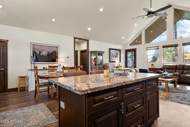 a kitchen with a stove a refrigerator a sink dishwasher with couches and dinning table with wooden floor