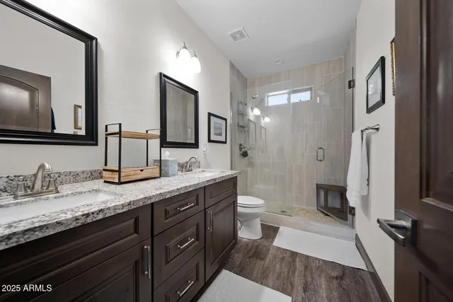a bathroom with a granite countertop sink toilet and shower