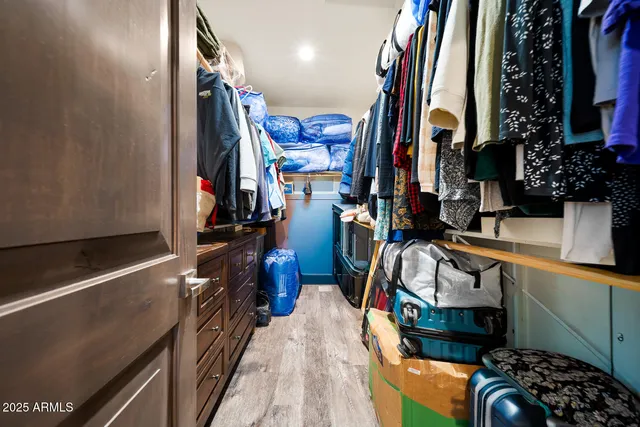 a view of walk in closet with clothes and shoes