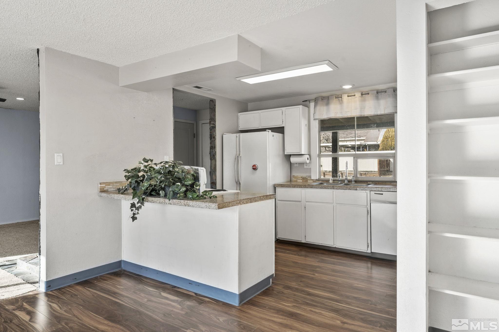 3810 Snipe Drive Reno, NV 89508 - Photo 5 of 38 a kitchen with white cabinets and wooden floor