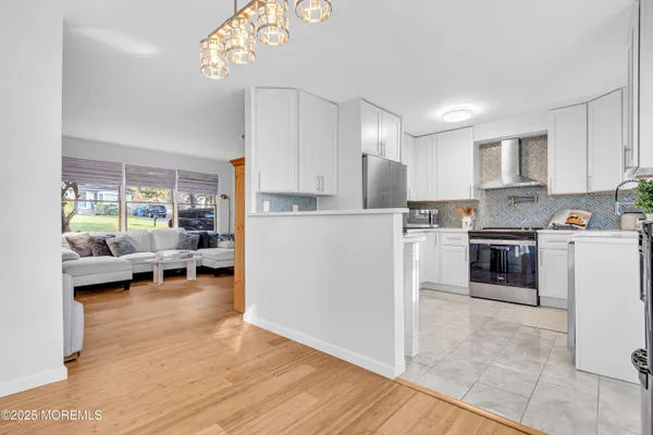 a kitchen view with white cabinets and stainless steel appliances