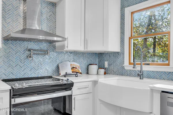 a kitchen with a sink and a stove next to a window