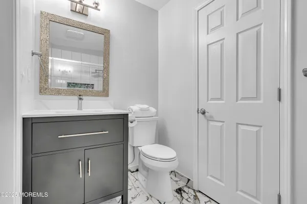 a bathroom with a toilet a sink and mirror