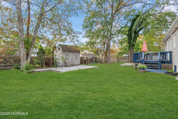 a view of a house with backyard and a tree