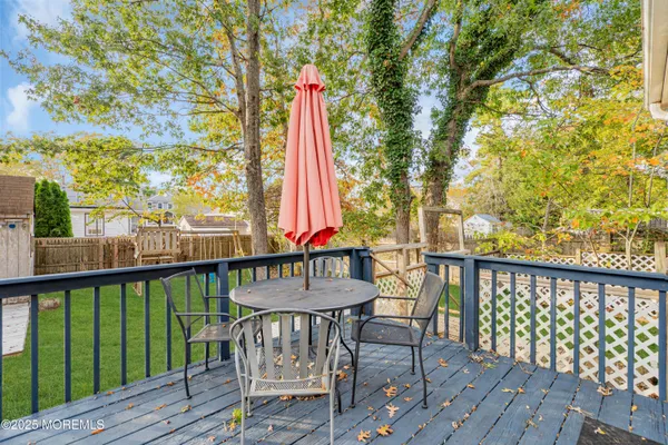 a view of a deck with a table and chairs with wooden floor and fence