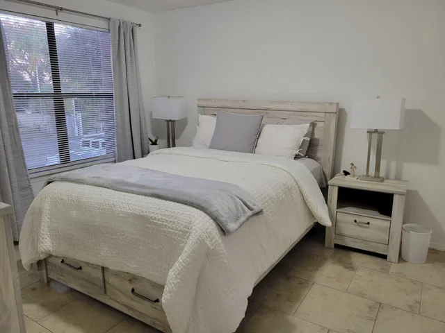 a bedroom with a bed and a window