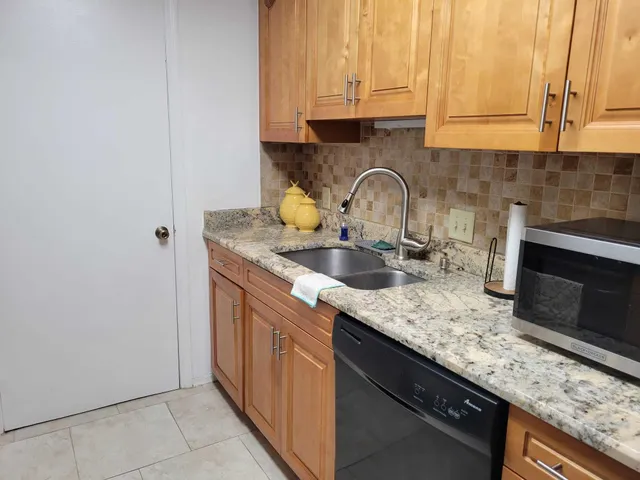 a kitchen with granite countertop a sink and a stove