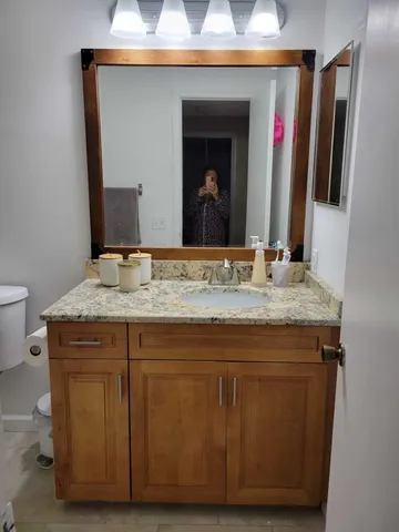 a bathroom with a granite countertop sink and a mirror