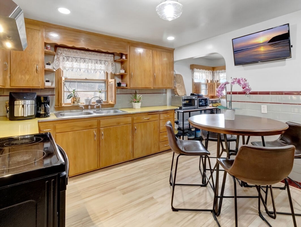 222 Walnut Street Saugus, MA 01906 - Photo 14 of 42 a kitchen with a dining table chairs and flat screen tv