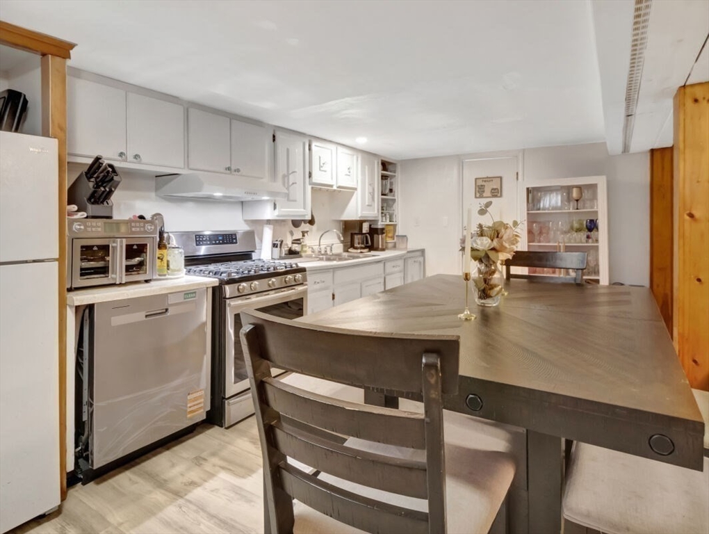 222 Walnut Street Saugus, MA 01906 - Photo 19 of 42 a kitchen with a table chairs microwave and cabinets