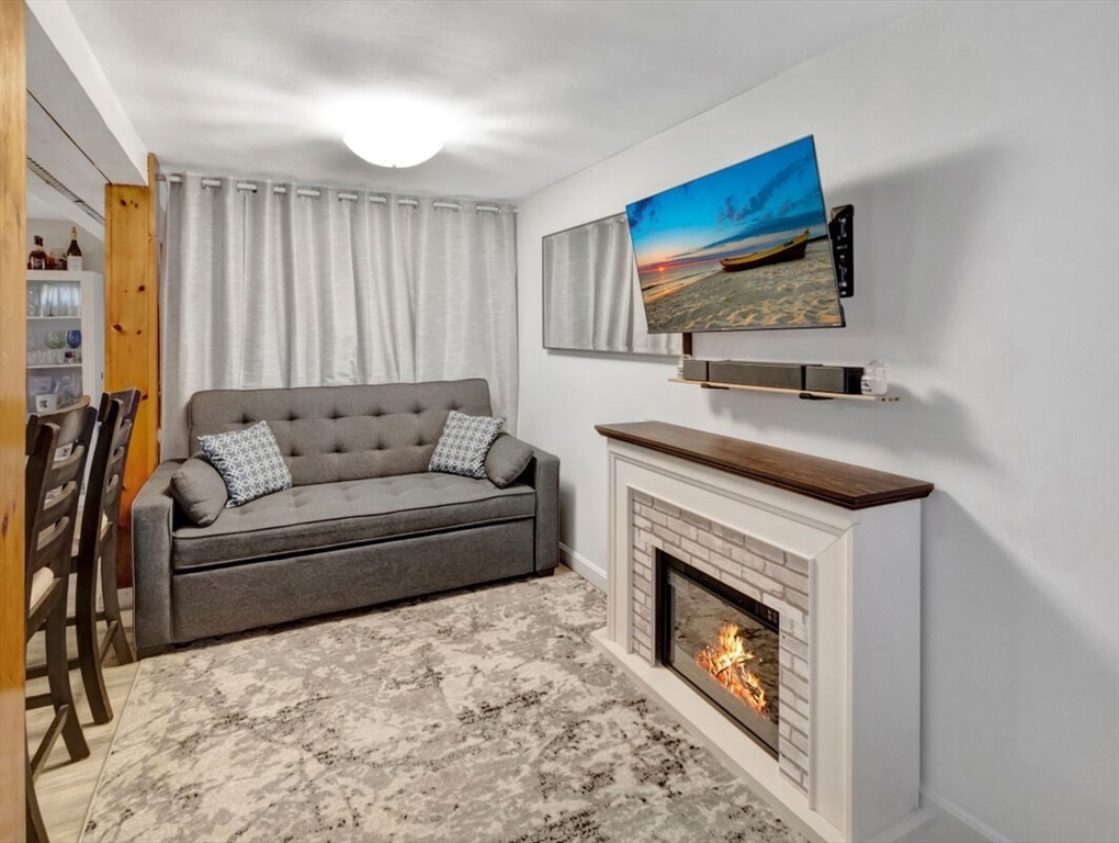 222 Walnut Street Saugus, MA 01906 - Photo 23 of 42 a living room with furniture a fireplace and a flat screen tv