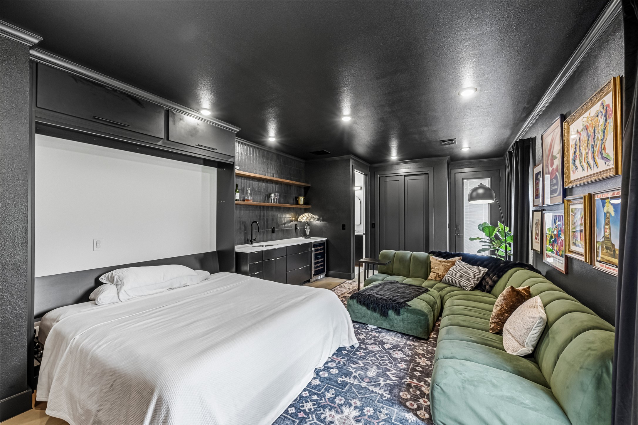 14302 Fallen Timber Drive Austin, TX 78734 - Photo 18 of 37 This versatile living area features a built-in wall bed, a wet bar with open shelving and cabinetry, and recessed lighting