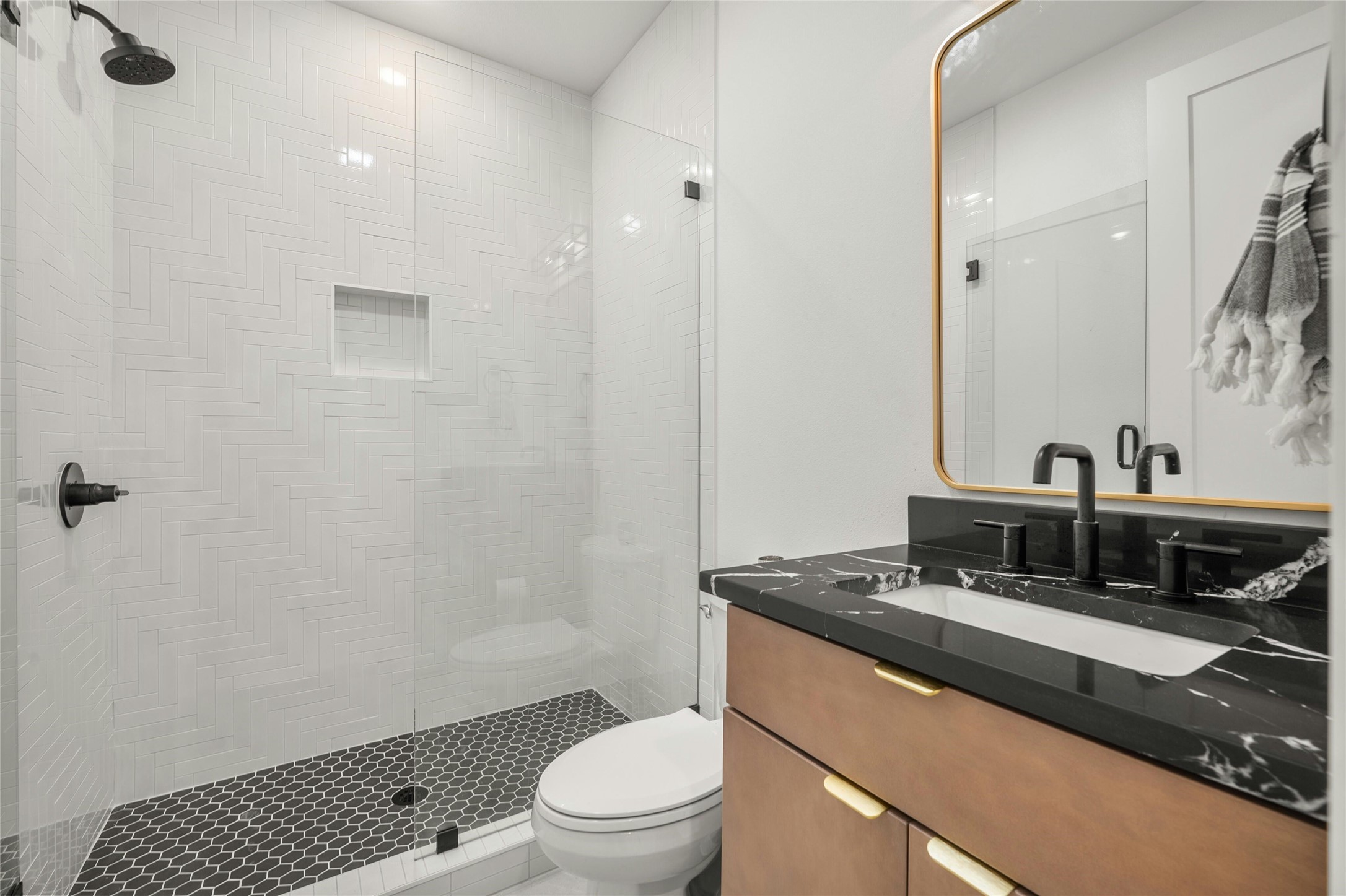 14302 Fallen Timber Drive Austin, TX 78734 - Photo 23 of 37 This bathroom features a contemporary vanity with a black countertop and a rectangular sink, complemented by matte black fixtures