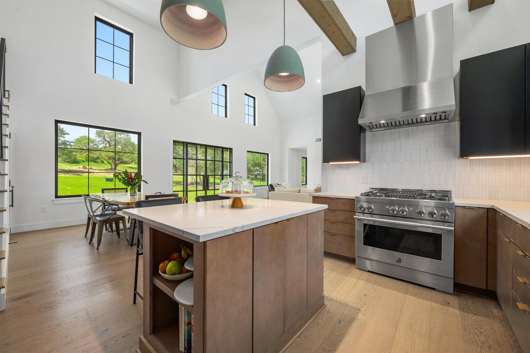 14302 Fallen Timber Drive Austin, TX 78734 - Photo 9 of 37 This property features a kitchen with a large central island, stainless steel appliances, and wood flooring