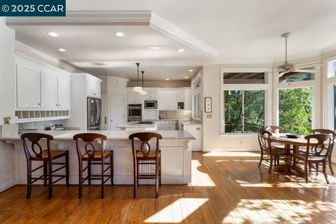 a dining room with furniture water view and large windows