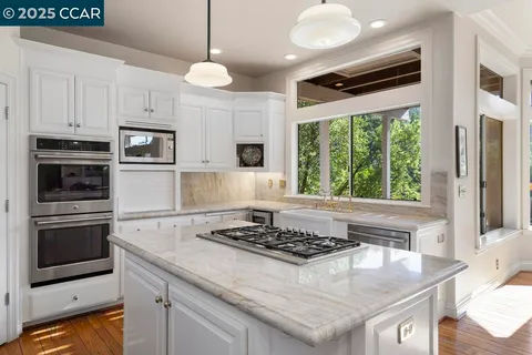 a kitchen with stainless steel appliances granite countertop a stove a refrigerator and a microwave