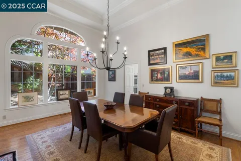 a view of a dining room with furniture a chandelier and wooden floor