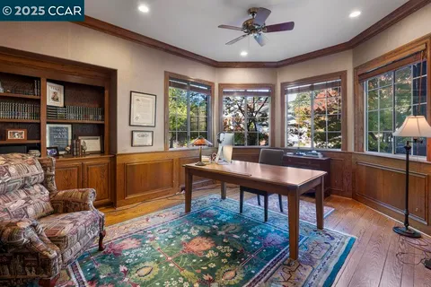 a living room with furniture a rug and a floor to ceiling window