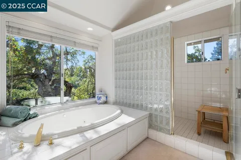 a spacious bathroom with a granite countertop sink a mirror and a bathtub