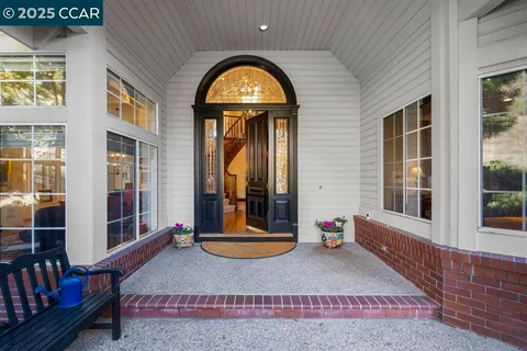 a view of a brick house with large windows and a yard