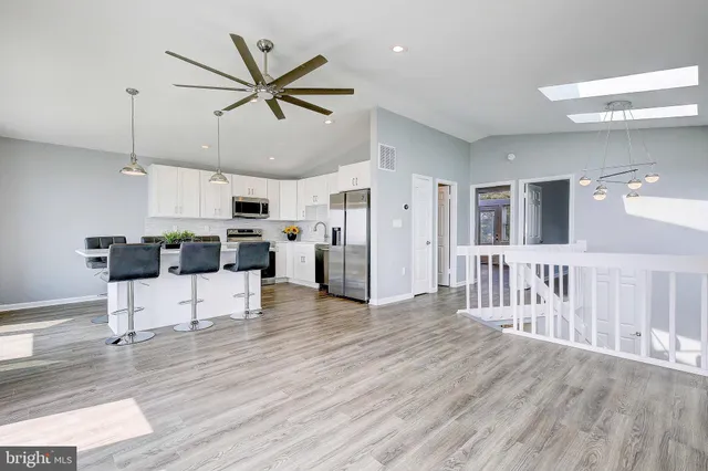 a view of a kitchen with refrigerator microwave and wooden floor