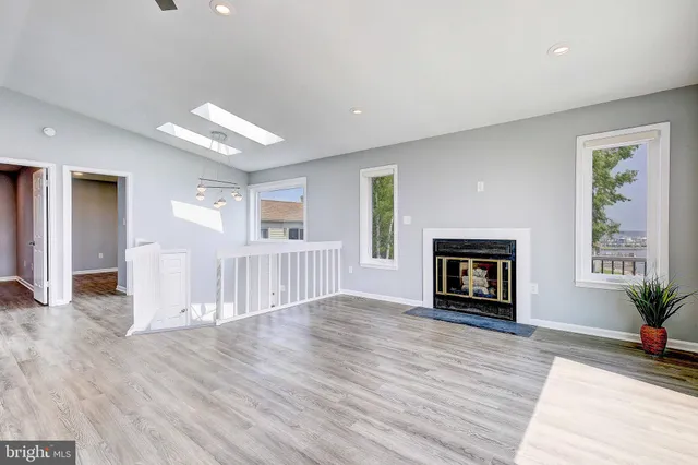 a view of empty room with wooden floor and a fireplace