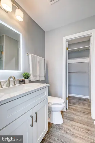 a bathroom with a granite countertop toilet sink and mirror