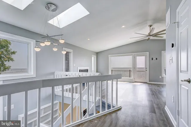 a view of a hallway with wooden floor and chandelier