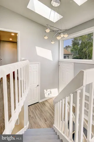 a view of a hallway with wooden floor and staircase