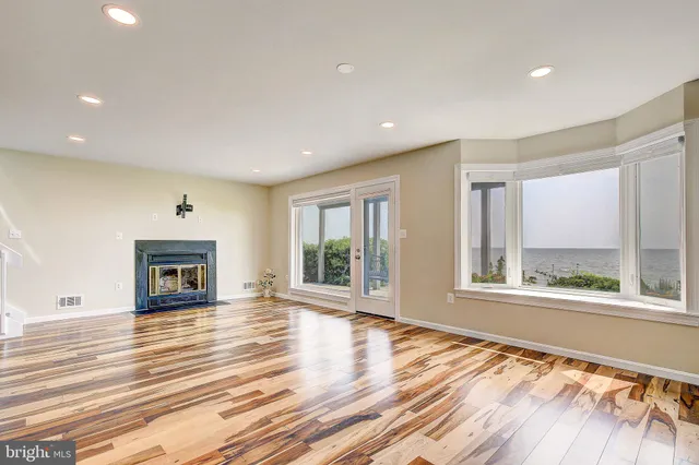 a view of an empty room with a window and fire place