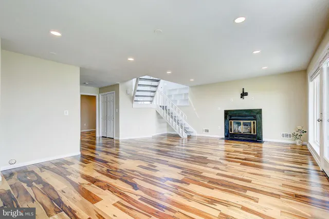 a view of empty room with wooden floor and fireplace