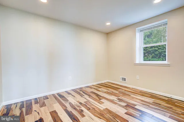 a view of a big room with wooden floor and windows