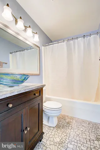 a view of a kitchen with kitchen island a sink and wooden floor