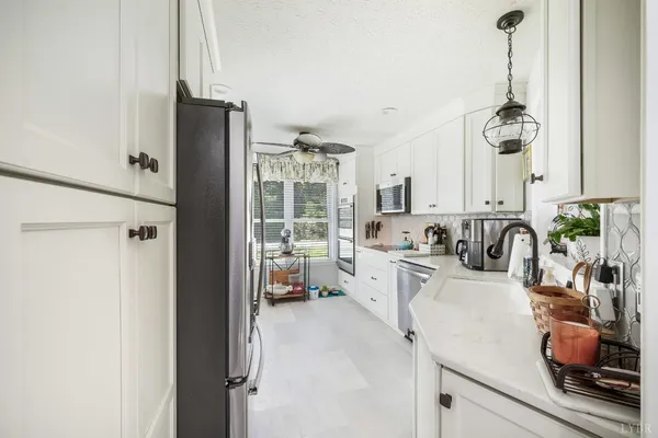 a kitchen with stainless steel appliances white cabinets and wooden floor