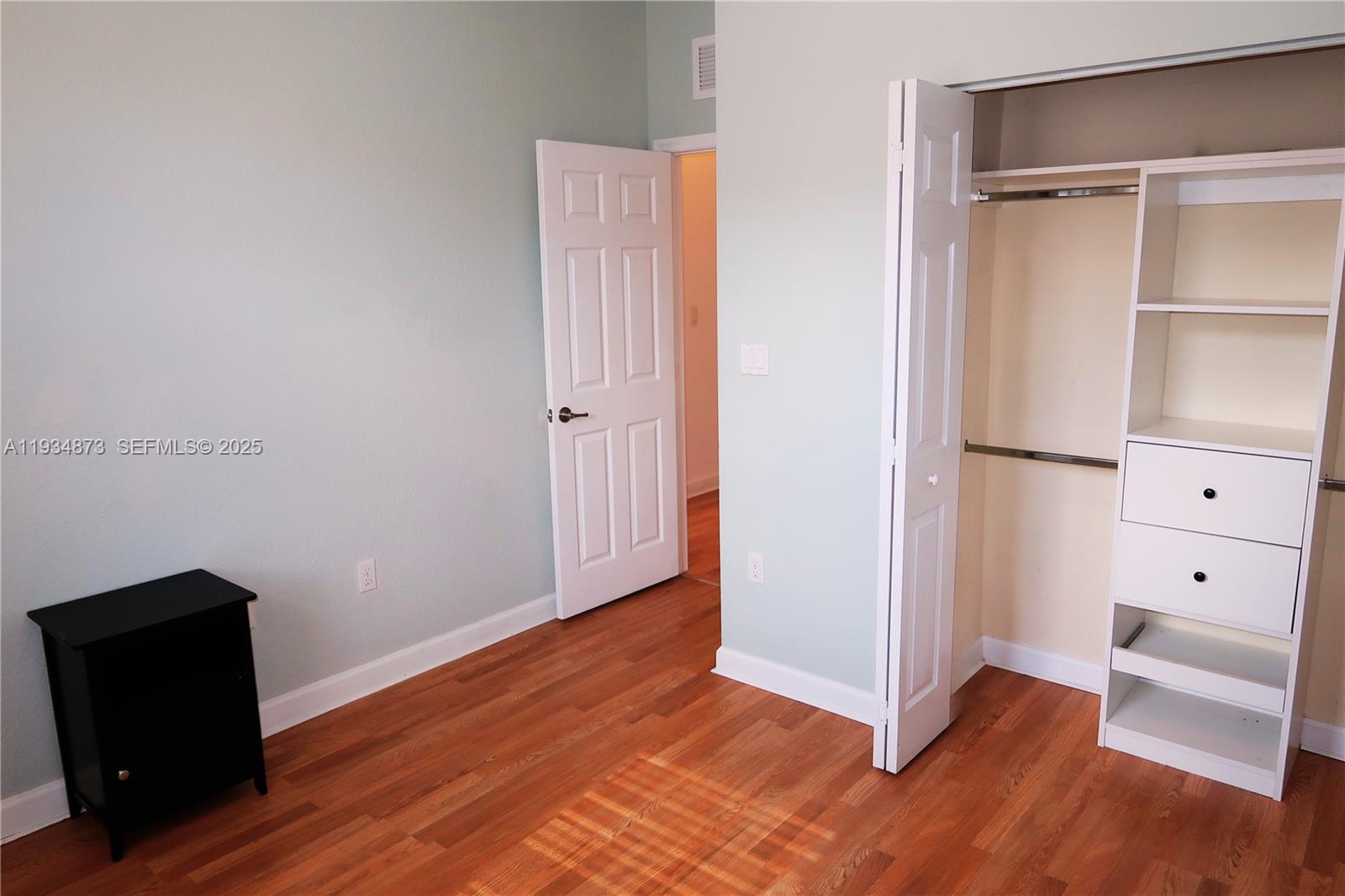 11334 Southwest 236th Street, Unit 11334 Homestead, FL 33032 - Photo 12 of 25 a view of an empty room with wooden floor and a window