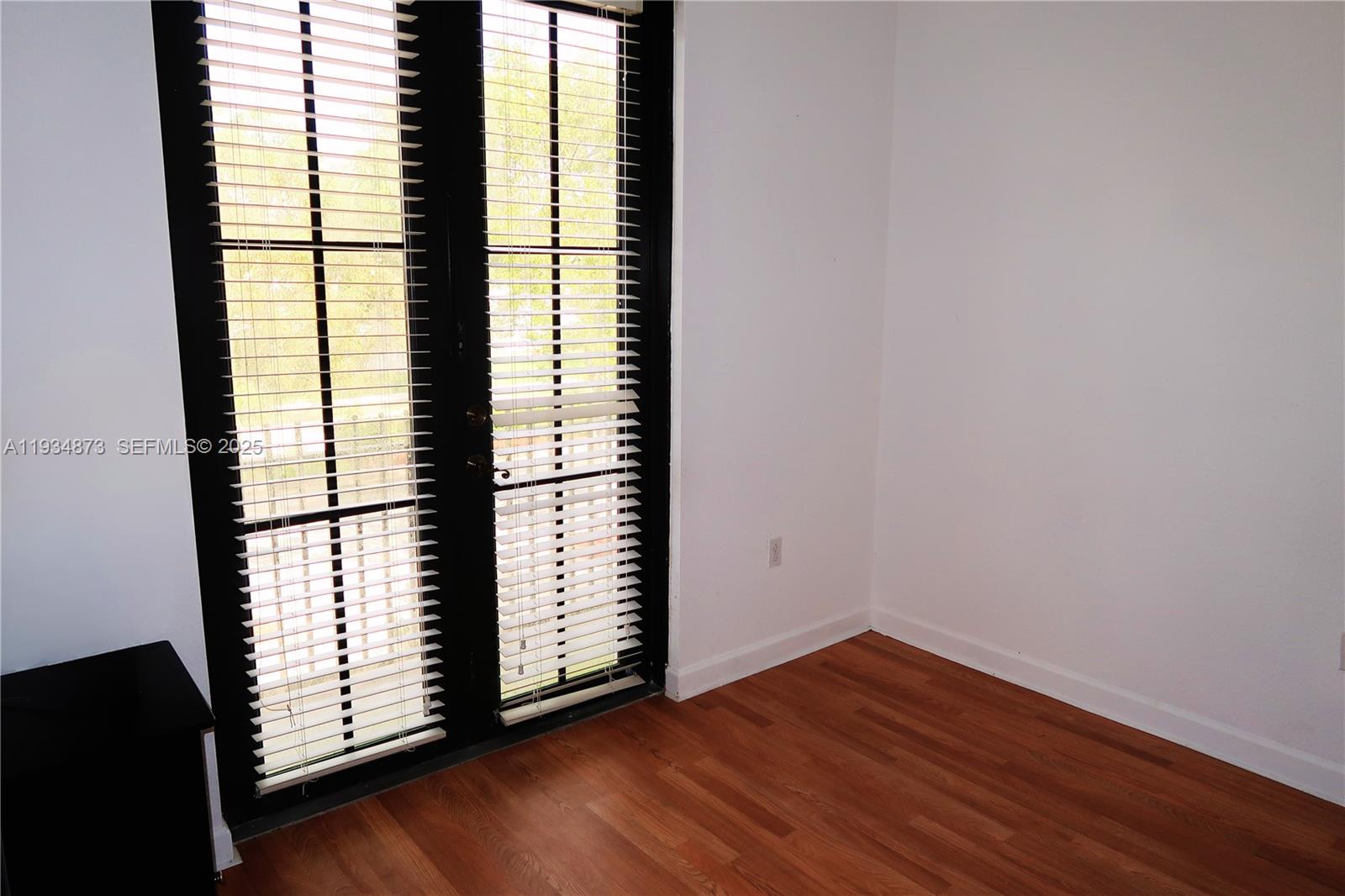 11334 Southwest 236th Street, Unit 11334 Homestead, FL 33032 - Photo 21 of 25 an empty room with wooden floor and windows