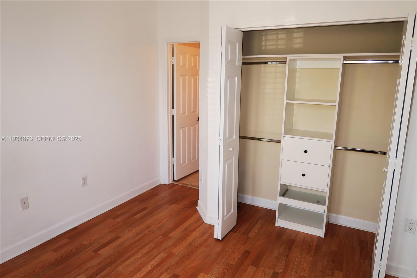 11334 Southwest 236th Street, Unit 11334 Homestead, FL 33032 - Photo 22 of 25 a view of walk in closet with wooden floor and window