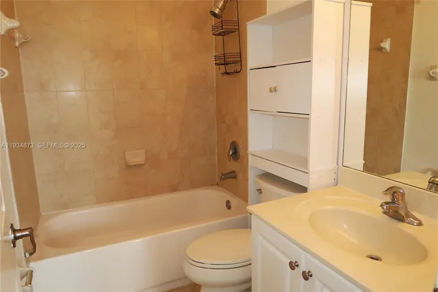 a bathroom with a bathtub shower sink vanity and toilet