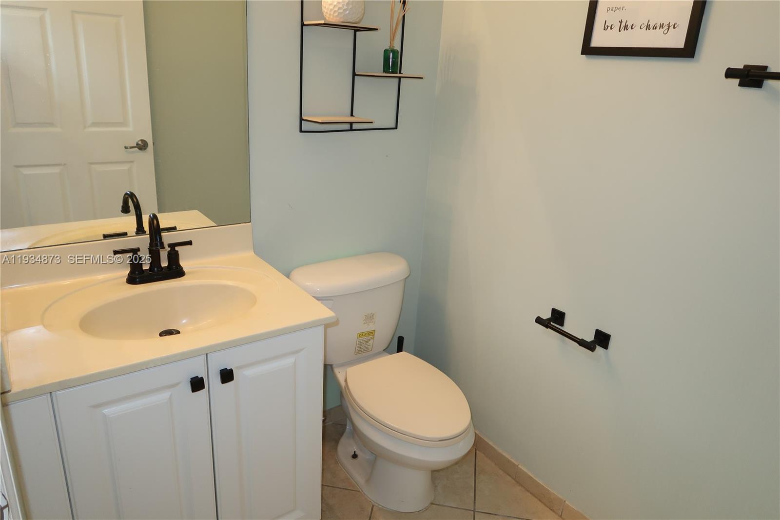 11334 Southwest 236th Street, Unit 11334 Homestead, FL 33032 - Photo 4 of 25 a bathroom with a sink a toilet and mirror