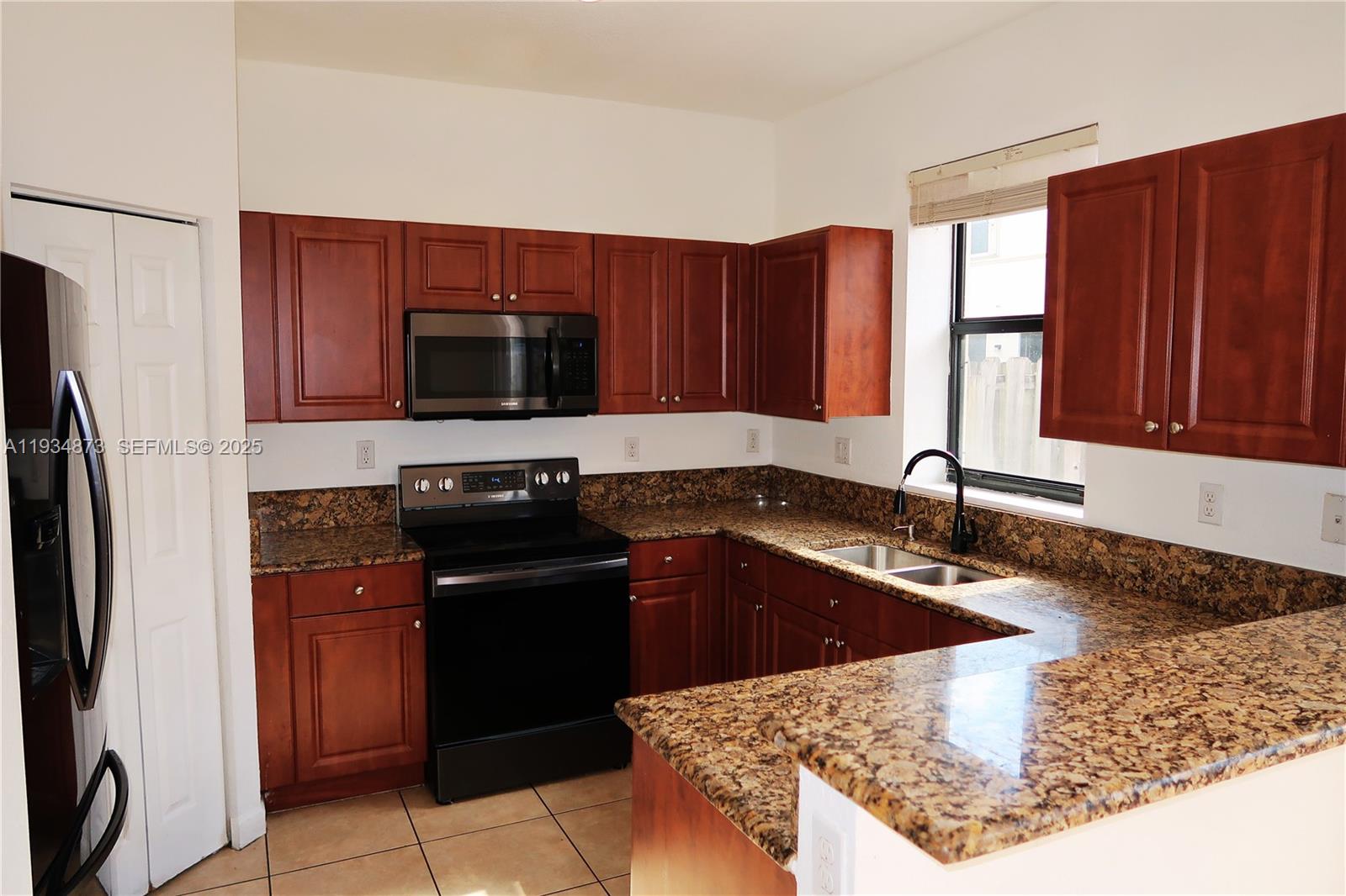 11334 Southwest 236th Street, Unit 11334 Homestead, FL 33032 - Photo 8 of 25 a kitchen with a sink stove and refrigerator
