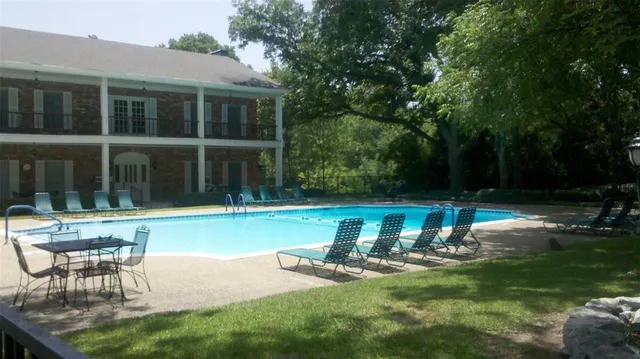 a view of a house with backyard sitting area and swimming pool