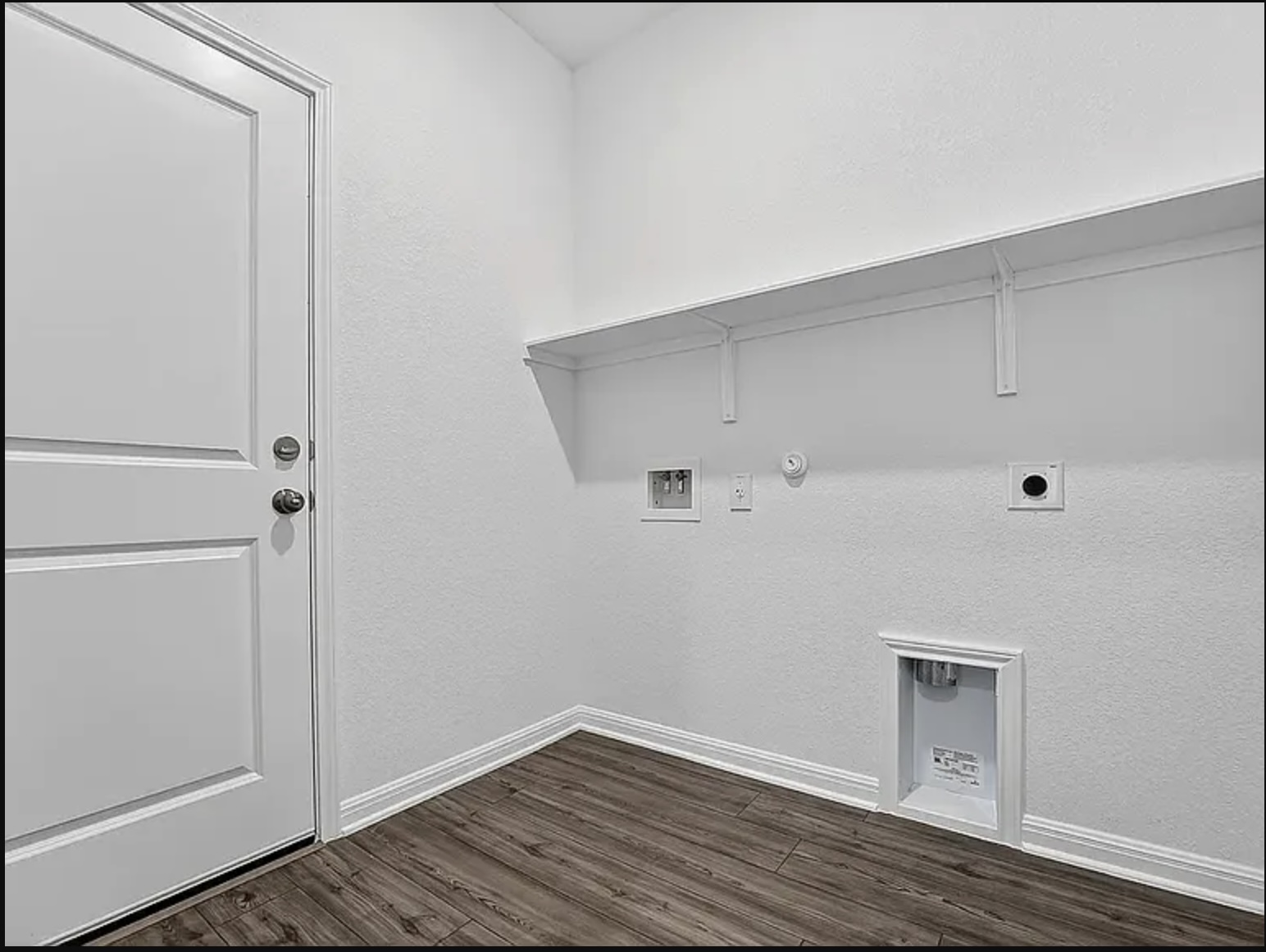 203 Betsy Road Hutto, TX 78634 - Photo 14 of 21 Rich wood-look flooring and built-in shelving define this functional laundry room space.
