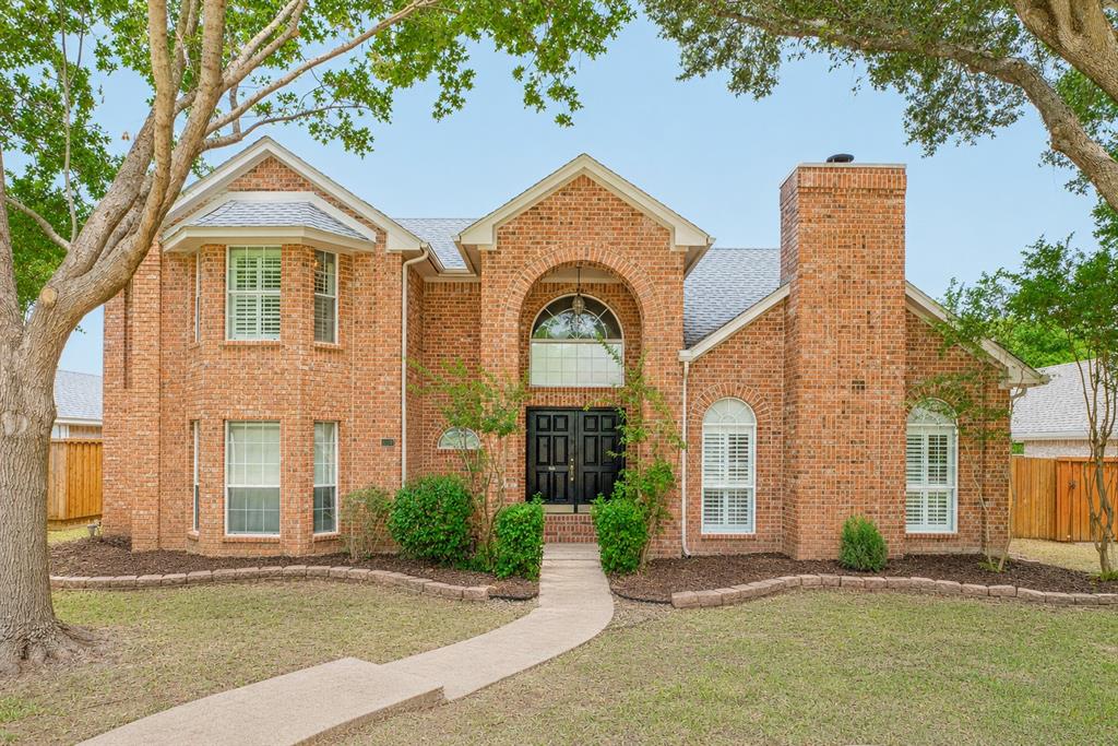 1215 Spring Creek Drive Allen, TX 75002 - Photo 1 of 40 Brick exterior with a prominent arched entry, dual black front doors, and a decorative arched window